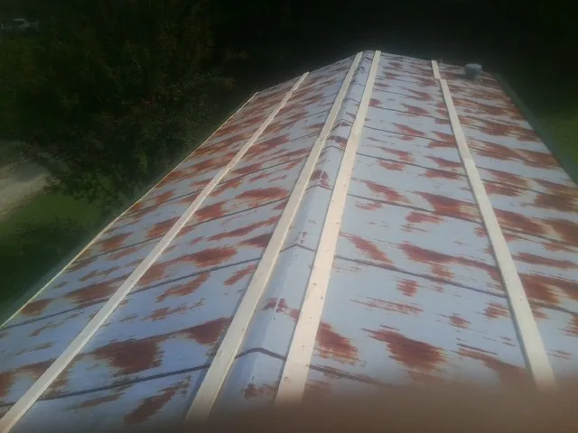 Rusted metal roof panels with new wood purlins before replacement — Storm Damage Roof Repair in Calder by Roofing Brothers