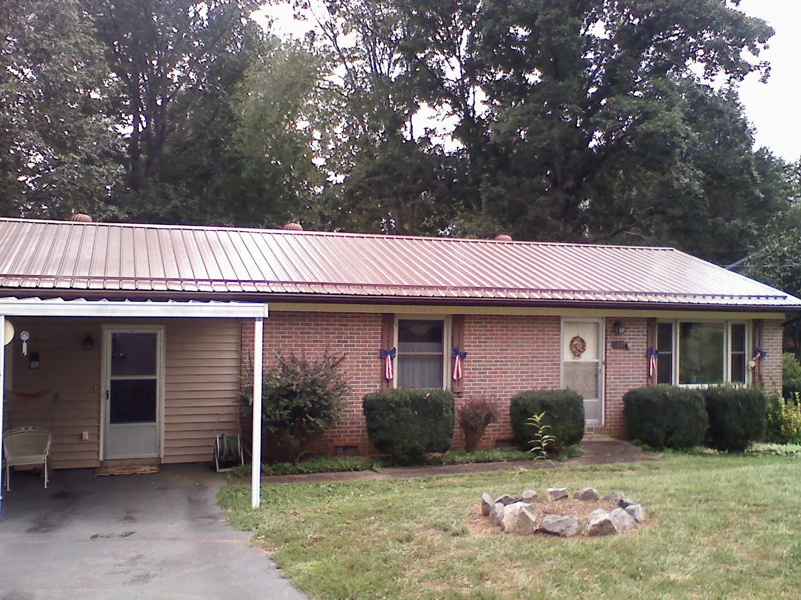 Bronze metal roof and carport on a brick ranch home — Roof Repair work by our crew in Calder