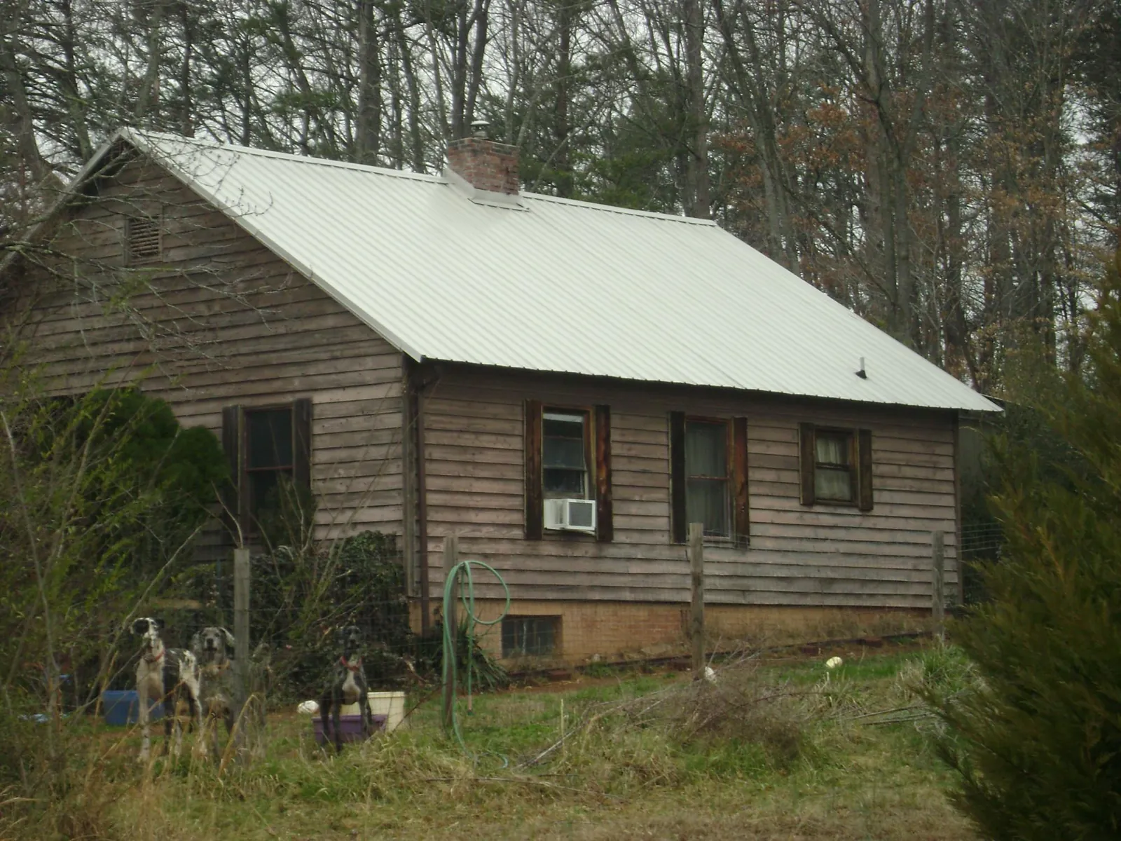 White metal roof on an old wood sided farmhouse, from a Metal Roof Installation job in Calder